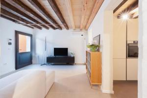 a living room with a couch and a tv at Ca' Ferrando, brand new apartment, experienced host! in Venice