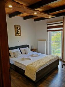 a large bed in a room with a large window at Apartman Silvija in Otočac