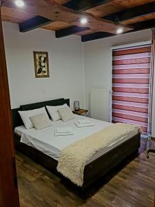 a bedroom with a large bed with a red door at Apartman Silvija in Otočac