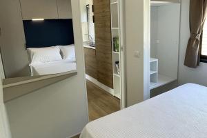 a small bedroom with a bed and a mirror at Le Dune Villaggio in Lido Di Fondi
