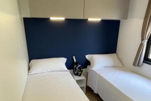 a bedroom with two beds and a blue wall at Le Dune Villaggio in Lido Di Fondi