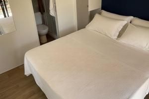 a large white bed in a room with a toilet at Le Dune Villaggio in Lido Di Fondi