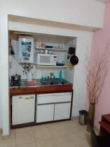 una pequeña cocina con fregadero y microondas en APART OBELISCO CENTRO AA Wi Fi en Buenos Aires