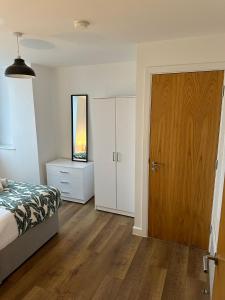 a bedroom with a bed and a wooden door at Stunning City View Apartment by Central Stay in Liverpool