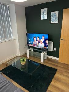 a living room with a flat screen tv on a wall at Stunning City View Apartment by Central Stay in Liverpool