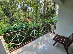a balcony with a bench and a view of trees at Pknhomestay kumily thekkady in Thekkady