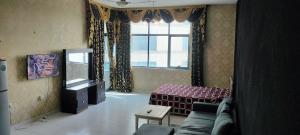 uma sala de estar com um sofá e uma janela em Private Room with Separate Bathroom and balcony em Ajman