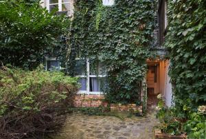 an ivy covered building with a door and a window at Studio proche Roland Garros in Boulogne-Billancourt