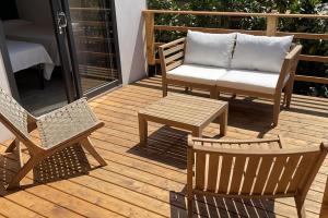 a wooden deck with chairs and a couch and a table at Le Dune Villaggio in Lido Di Fondi