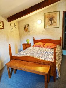 a bedroom with a wooden bed and a wooden table at Le cabinet de curiosités in Aiguèze