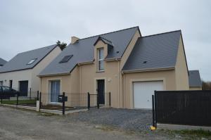 una casa con una valla delante de ella en Les embruns, maison neuve près des plages, en Asnelles