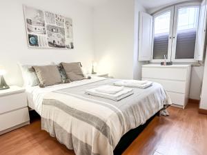 een witte slaapkamer met een bed met twee handdoeken erop bij T2 Apartment -Cascais center - 100m from beach in Cascais