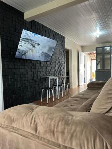 a room with four beds and a tv on the wall at Casa Cachoeira do bom Jesus in Florianópolis