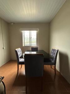 a dining room with a table and two chairs at Casa Cachoeira do bom Jesus in Florianópolis