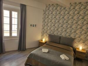 a bedroom with a bed with two towels on it at Chez L's in Menton