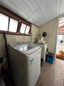 a laundry room with a washing machine and a washer at Casa Cachoeira do bom Jesus in Florianópolis