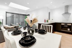 cocina y sala de estar con mesa y sillas en New Build Haven - Close to City Centre - Etihad, en Mánchester