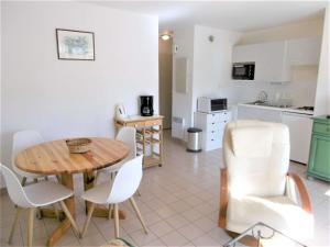 cocina y comedor con mesa y sillas en Appartement 2 à 4 personnes à 50 m du port de St Jacques - Kolen, en Sarzeau