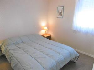 1 dormitorio con 1 cama con edredón azul en Appartement 2 à 4 personnes à 50 m du port de St Jacques - Kolen, en Sarzeau