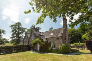 ein altes Steinhaus mitten im Hof in der Unterkunft Drumlanrig Mains Cottage in Thornhill