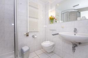 Baño blanco con lavabo y aseo en Haus Rügensonne, App 02 en Baabe