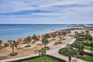 Ancient Sands Golf Resort and Residences في الغردقة: اطلالة جوية على شاطئ به نخيل والمحيط