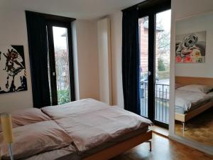 een slaapkamer met een bed en een balkon met ramen bij exklusive Wohnung in Architekten Villa, nähe Theater in Meiningen