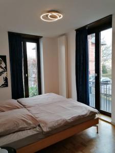 een slaapkamer met een bed en 2 grote ramen bij exklusive Wohnung in Architekten Villa, nähe Theater in Meiningen