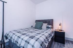 een slaapkamer met een bed met een zwart-witte deken bij LFC Themed Apartment in Liverpool
