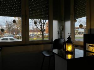 Habitación con mesa, silla y 2 ventanas en Studio apartman Avenija ***, en Slavonski Brod