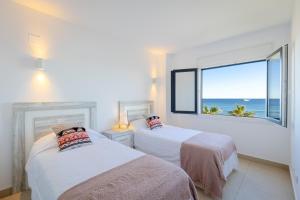 2 Betten in einem Zimmer mit Meerblick in der Unterkunft Fidalsa Paradise Sea Punta Prima in Torrevieja