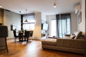 uma sala de estar com um sofá e uma sala de jantar em Luxury Vista Haven - APT2, Free Parking em Zagreb