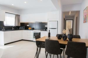 een keuken en eetkamer met een tafel en stoelen bij Utopia Residences "by Checkin" in Chersonissos