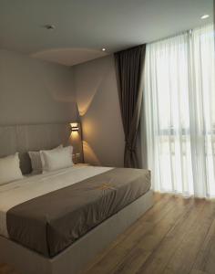 a bedroom with a bed and a large window at Metro Hotel Terminal in Tirana