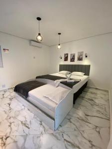 um quarto com 2 camas e piso em mármore em pousada fast sleep no Guarujá