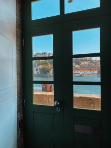 ポルトにあるPanorama Apartments Ribeira Portoのビーチと水辺の景色を望むドア