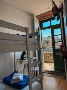ein Etagenbett mit einer Katze auf einem Tisch neben einem Fenster in der Unterkunft Panorama Apartments Ribeira Porto in Porto