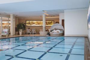 una piscina nella hall dell'hotel con piscina di Superior Sport und Familienresort Alpenblick a Zell am See