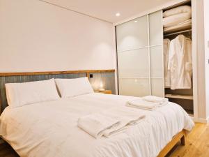 フンシャルにあるSHELL LIVING - Infinity Loftのベッドルーム(白いベッド1台、クローゼット付)