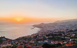 a view of a city and the ocean at sunset at SHELL LIVING - Infinity Loft in Funchal