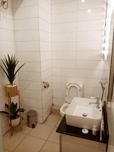 łazienka z białą umywalką i toaletą w obiekcie Golden Tulip Hotel- Evergreen Port Harcourt w mieście Port Harcourt
