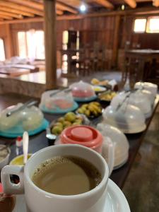 uma chávena de café sentada em cima de uma mesa em Pousada e Hostel Caminho de Santiago em Alto Paraíso de Goiás