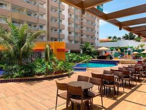 eine Terrasse mit Tischen und Stühlen neben einem Pool in der Unterkunft Olimpia Park resort in Olímpia