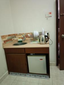 eine Küche mit einer Theke mit einer Spüle und einem Geschirrspüler in der Unterkunft Sofea Inn Bukit Merah - Suria A7245 in Simpang Ampat Semanggol