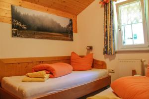 ガシュルンにあるAppartment Ganahlのベッドルーム1室(オレンジ色の枕が付いたベッド1台付)