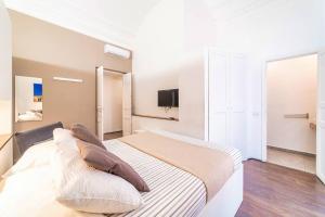 Un dormitorio blanco con una cama grande con almohadas. en Villa Bellini Luxury Home, en Catania