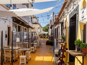 uma rua com mesas, cadeiras e guarda-sóis em T2 Apartment -Cascais center - 100m from beach em Cascais