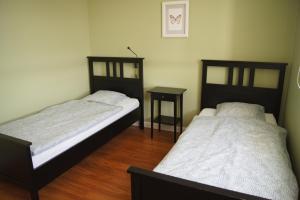 - 2 lits dans une chambre avec une table et un lit dans l'établissement Apartamenty Promenada Złotów, à Złotów