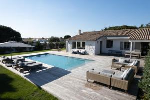 a backyard with a swimming pool and a house at Villa Madame - Pool - Near Beach and Golf in Les Portes