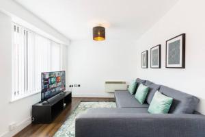 uma sala de estar com um sofá e uma televisão de ecrã plano em Duplex 2 Bedroom Apartment In City Nites - Near Arena - 2 Bathroom - City Centre em Birmingham